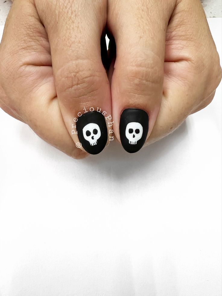 Edgy Skull-Themed Nail Art with Matte Black and White Motifs for Unique Expressions.