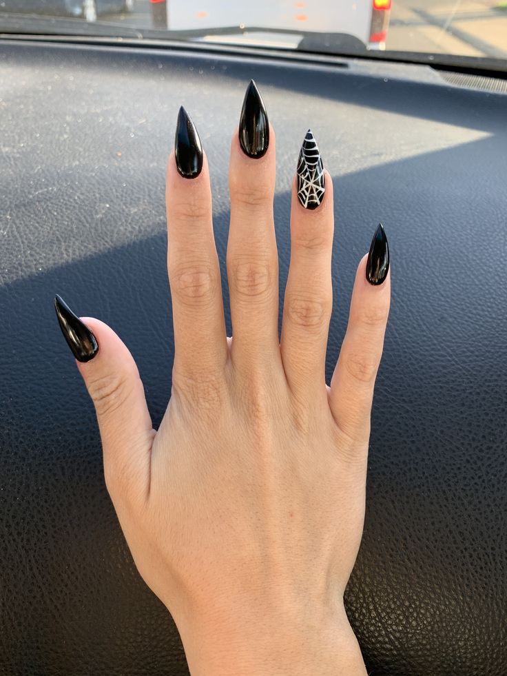 Dramatic Glossy Black Stiletto Nails with Edgy White Spider Web Accent.