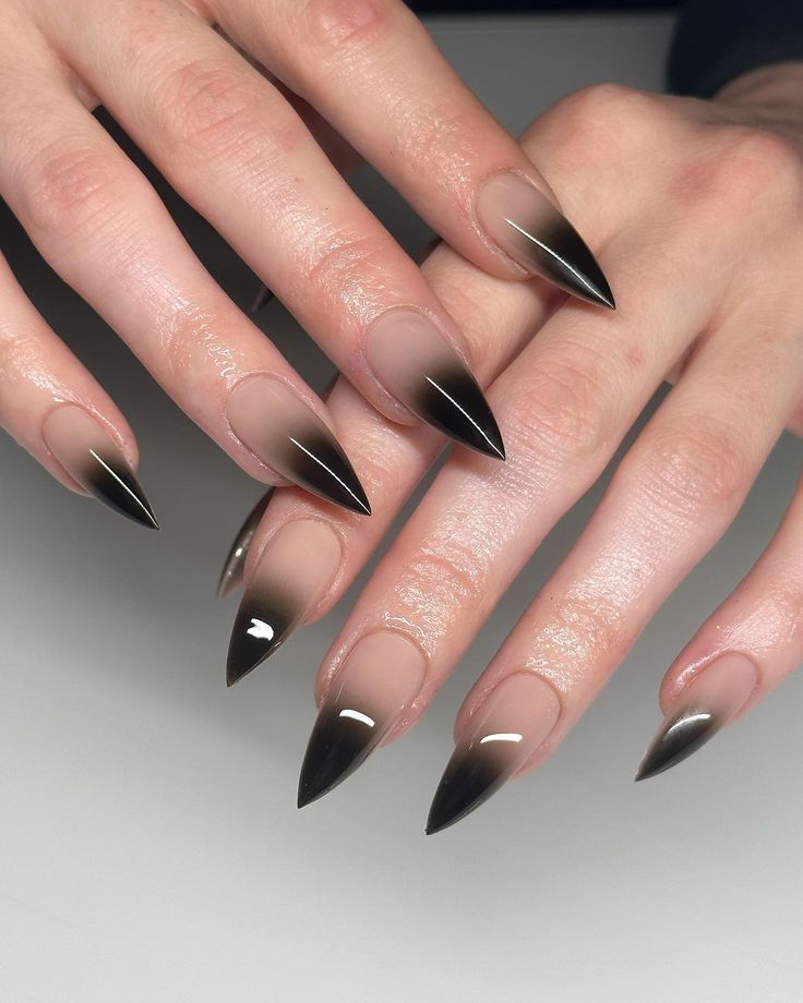 Captivating Ombre Stiletto Nails: A Bold Blend of Nude and Black for Modern Elegance.