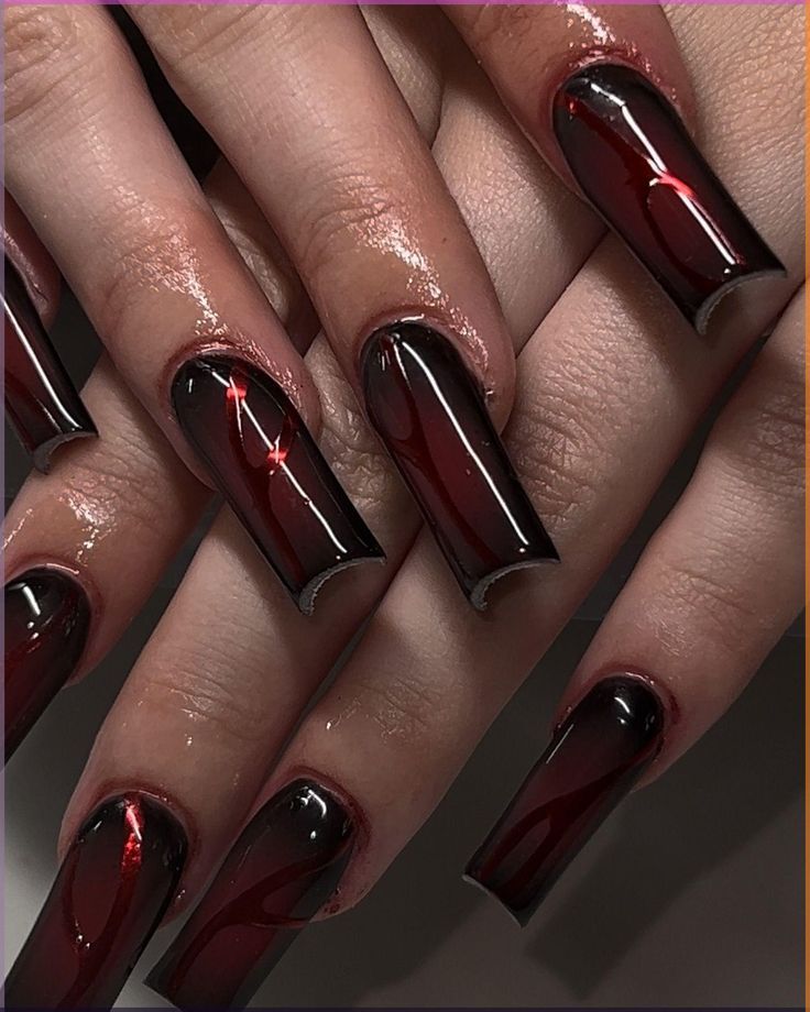 Striking Bold Nail Design: Glossy Black and Red Swirling Elegance