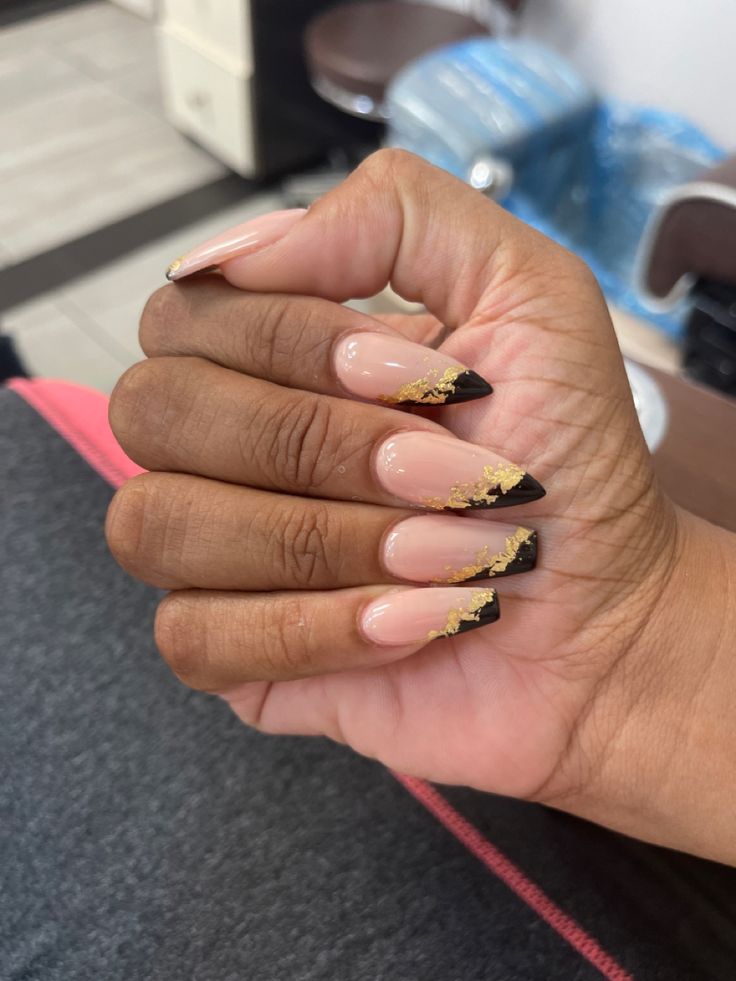 Sophisticated Nail Design: Nude and Deep Black with Gold Accents.