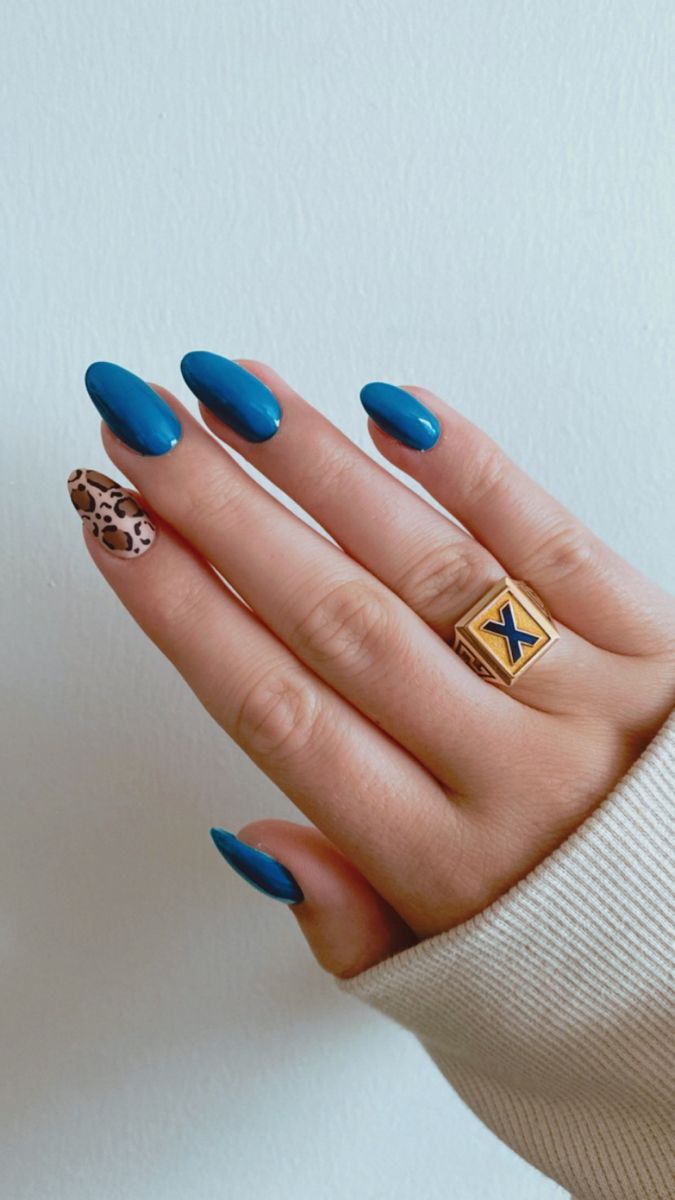 Chic Blue Nail Design with Leopard Accent and Gold Ring for a Bold Statement.