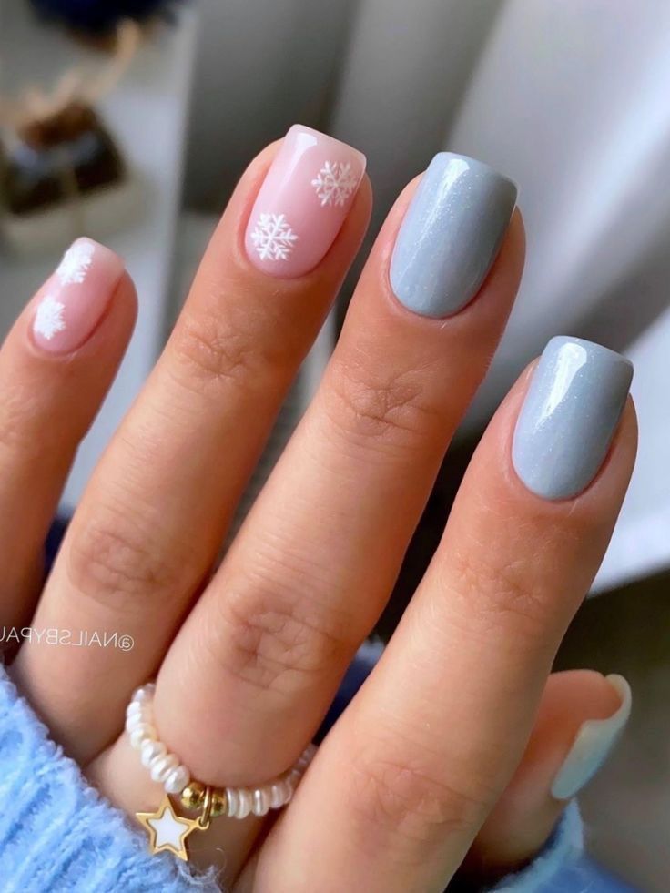 Elegant Winter Nail Design in Soft Pink and Cool Gray with Festive Snowflakes.