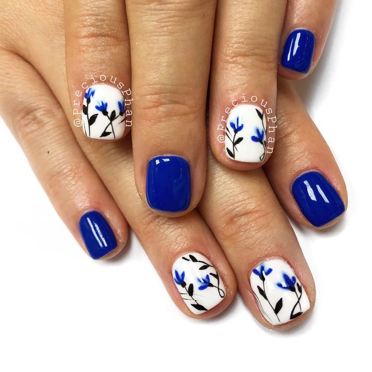 Elegant Floral-Accented Vibrant Blue Nail Design with Striking Contrast.