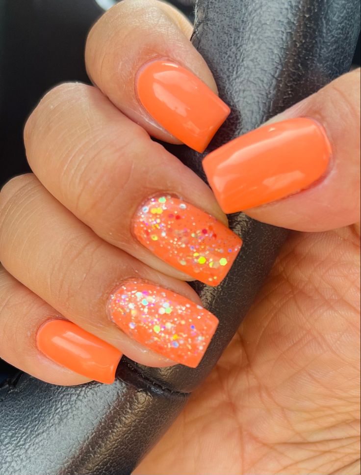 Cheerful Summer Aesthetic: Vibrant Orange Nails with Glittery Accent.