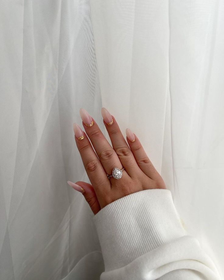 Sophisticated Soft Pink and Gold Almond Nail Design Perfect for Casual Outfits.