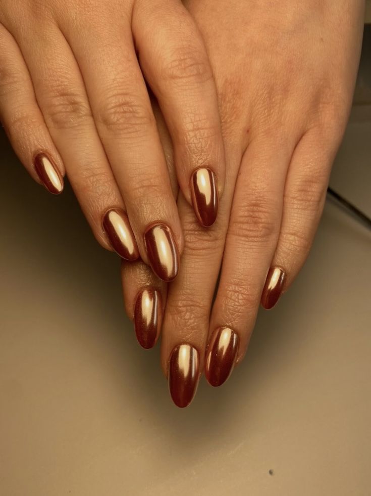 Elegant Two-Tone Almond-Shaped Nails: Deep Burgundy & Metallic Gold.