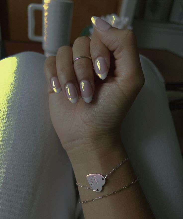 Sophisticated French Manicure with Glossy Tips and Elegant Jewelry Accents.