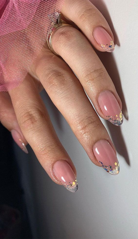 Chic Soft Peach Nail Design with Glossy Tips and Multicolored Glitter for a Festive Touch.