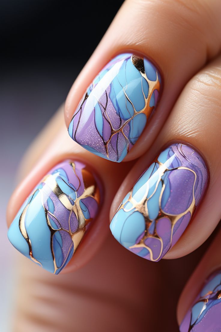 Elegantly Vibrant: Soft Blue and Lilac Marbled Nail Design with Gold Accents