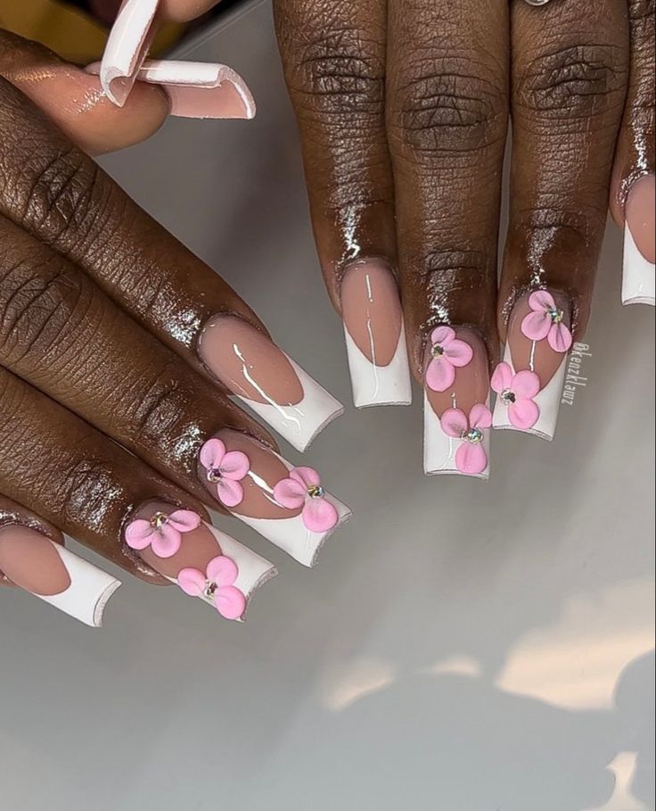 Elegant Floral Nail Design with Pink Flowers and Sparkling Gems on Long Nails.