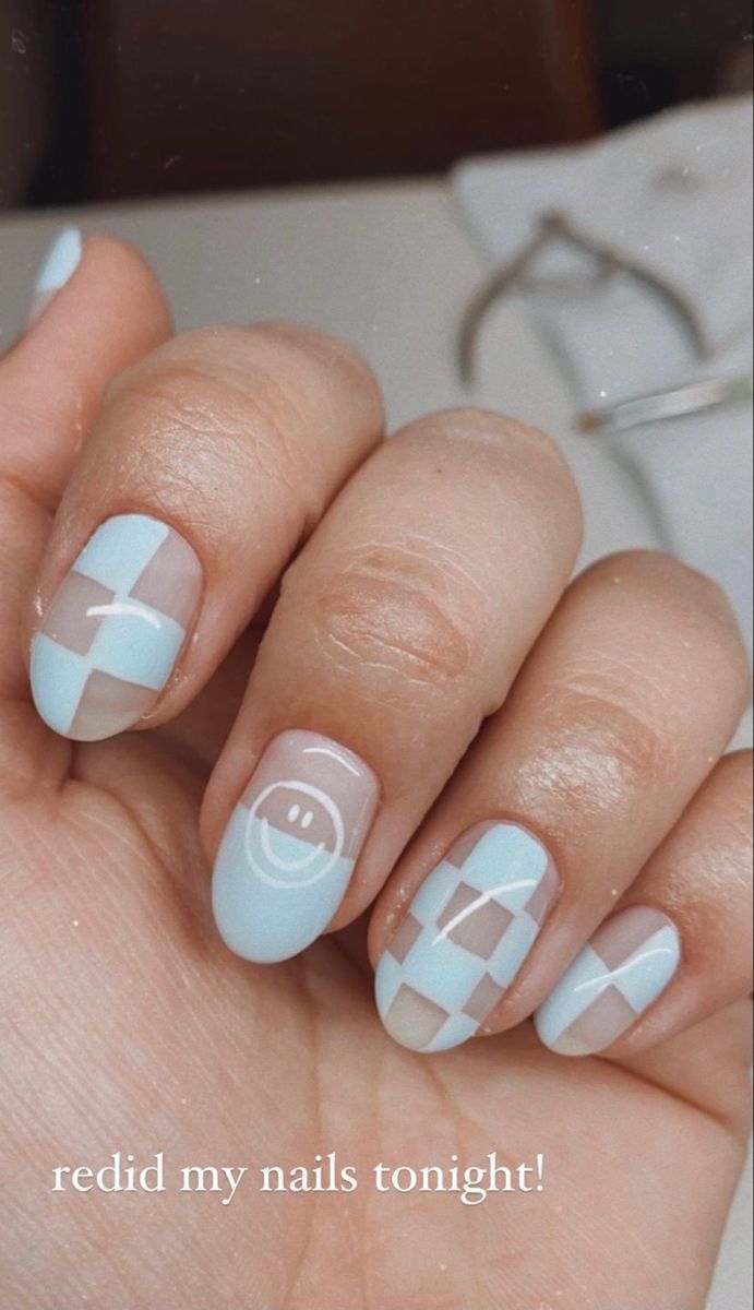 Trendy Pastel Blue Checkerboard Nail Design with Whimsical Smiley Faces.