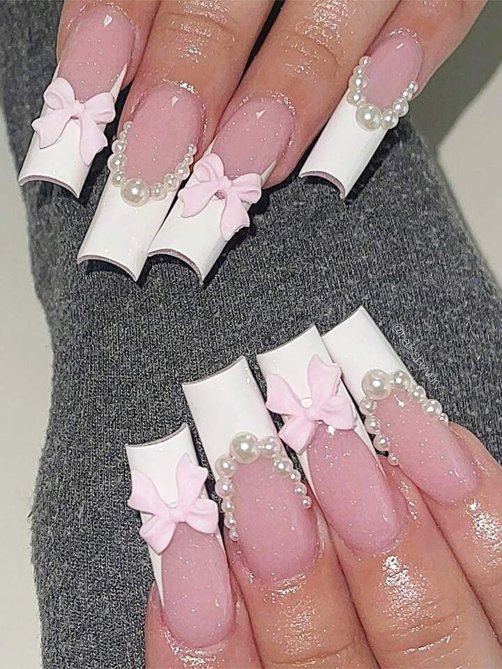 Sophisticated Blush Pink Nail Design with White Tips, Pink Bows, and Pearl Accents.