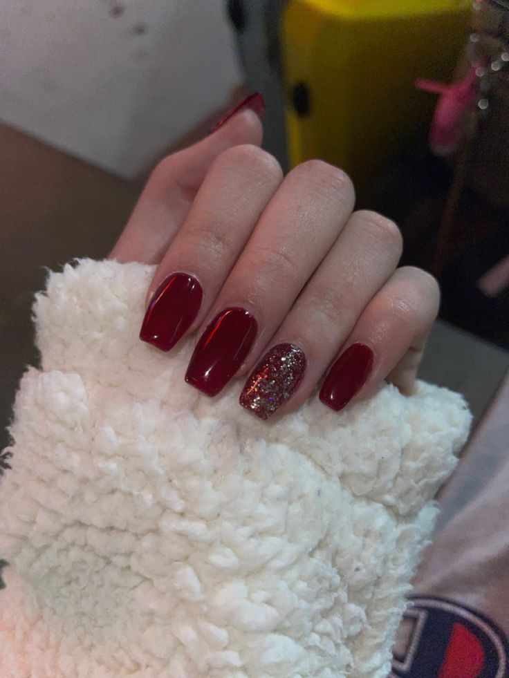 Sophisticated Glossy Red Nails with Playful Glitter Accent.