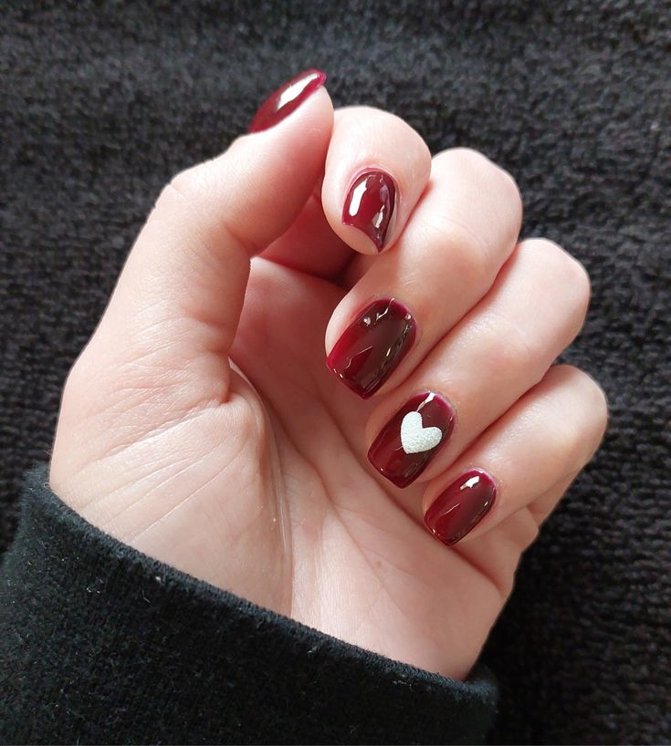 Chic Deep Burgundy Nail Design with Playful Heart Accent