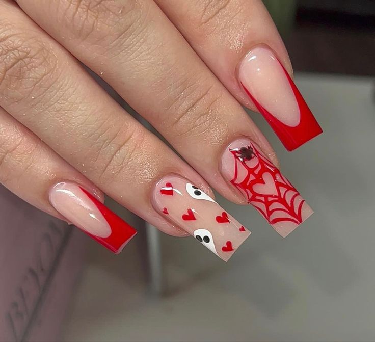 Whimsical Nail Design: Bold Red Tips with Heart Motifs and Spiderweb Accents.