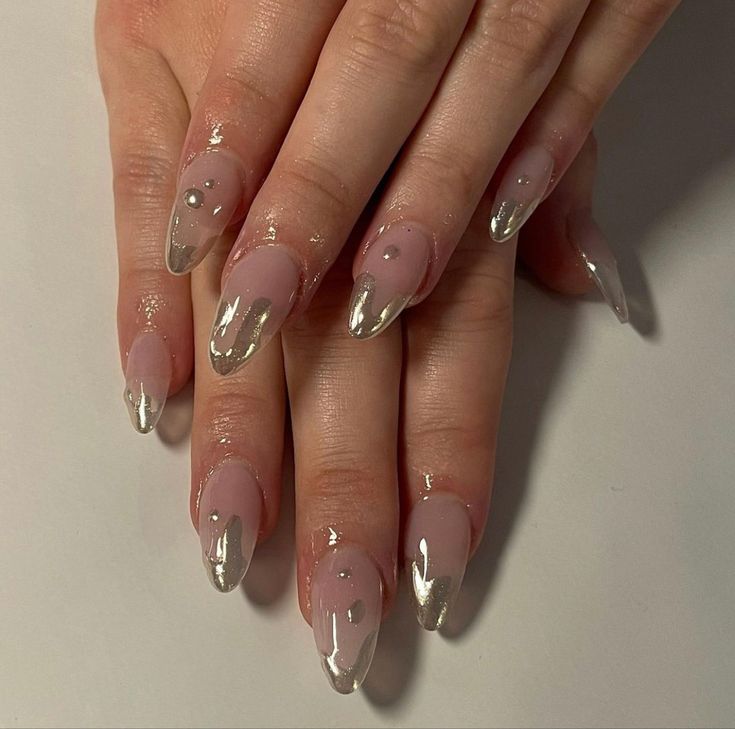 Sophisticated Long Nails: Nude Base with Metallic Silver Tips and Elegant Embellishments.