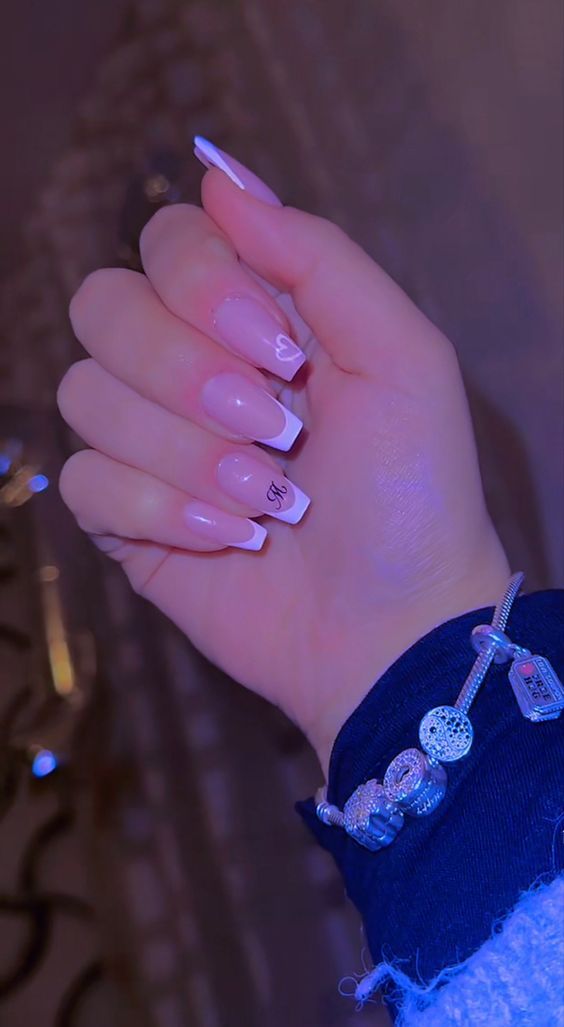 Chic French Manicure: Pastel Pink and White Tips with Subtle Heart Motif.