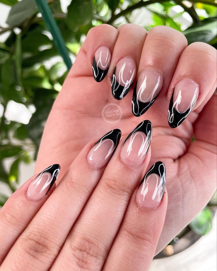 Elegant Nail Design with Sharp Black Tips and Delicate White Swirls