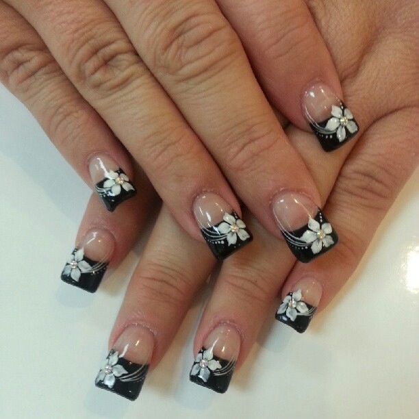 Sophisticated French Tip Nail Design with Black Base and Delicate Floral Accents.