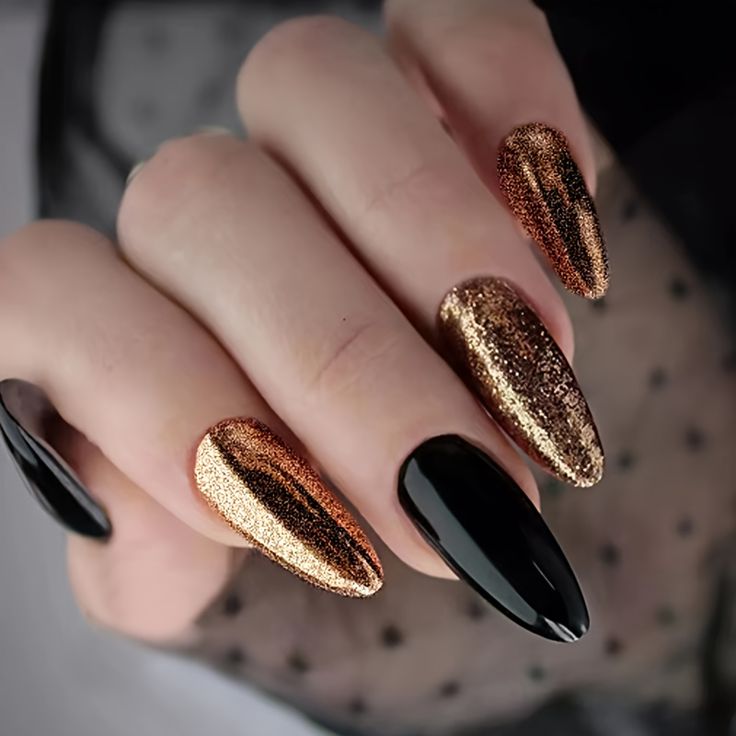 Elegant Almond-Shaped Nail Design in Glossy Black and Shimmering Gold with Glitter Accents