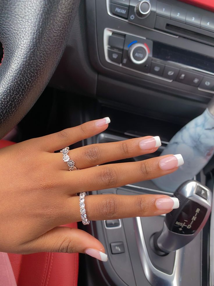 Timeless French Tip Manicure with Sparkling Rings for Elegant Occasions.