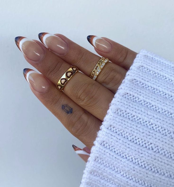 Chic Almond-Shaped Nails with Sophisticated French Tips and Gold Accents.