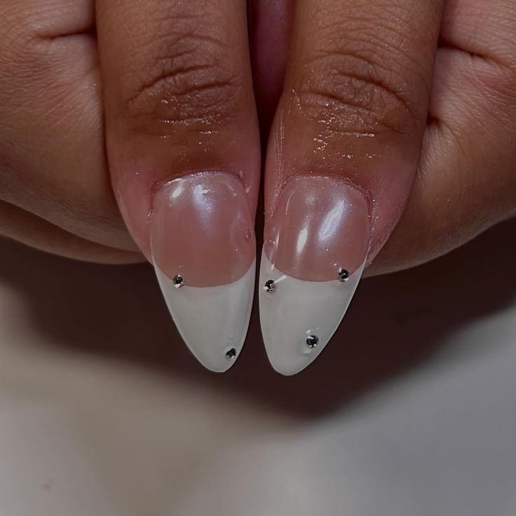 Elegant Almond-Shaped Nails with Glamorous French Tip Design and Silver Studs.