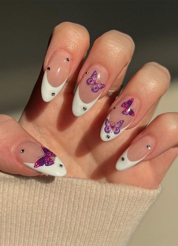 Whimsical White Tip Nail Design with Vibrant Purple Butterfly Accents.