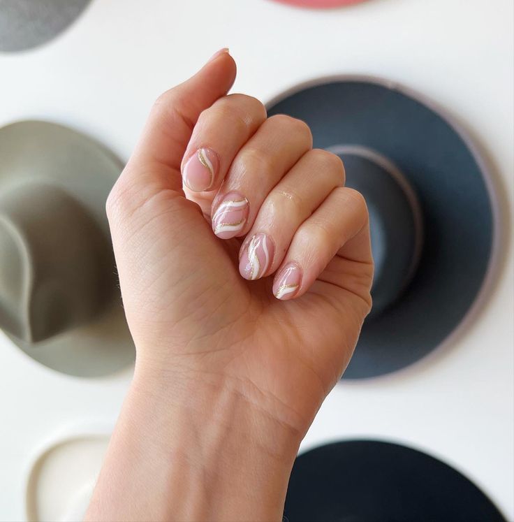 Chic Delicate Nail Design: Soft Pink Base with Elegant White Swirls.