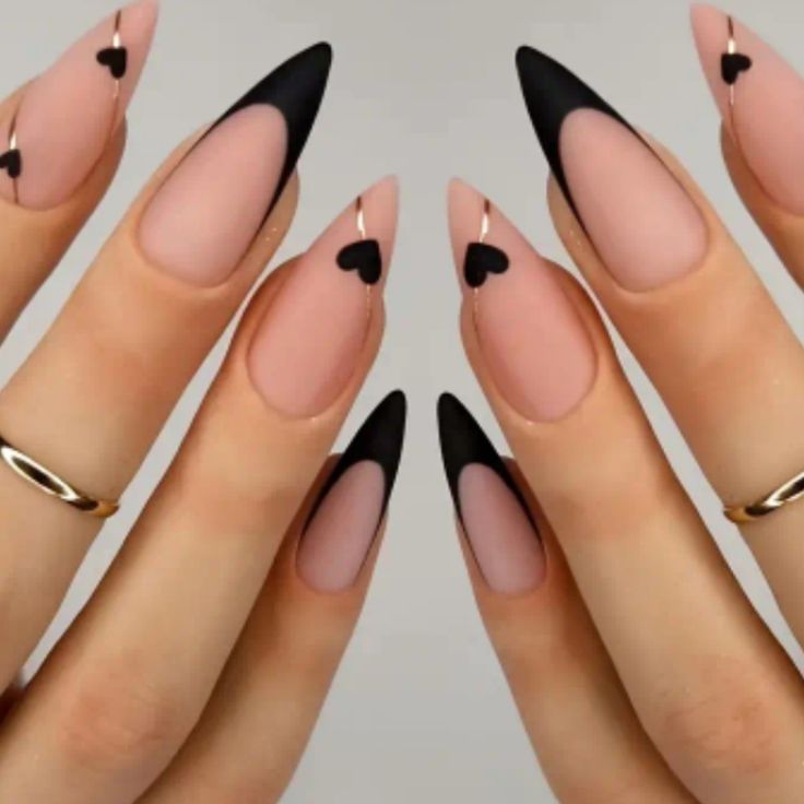 Chic Stiletto Nail Design: Soft Pink, Bold Black, Heart Motifs, and Elegant Gold Accents.