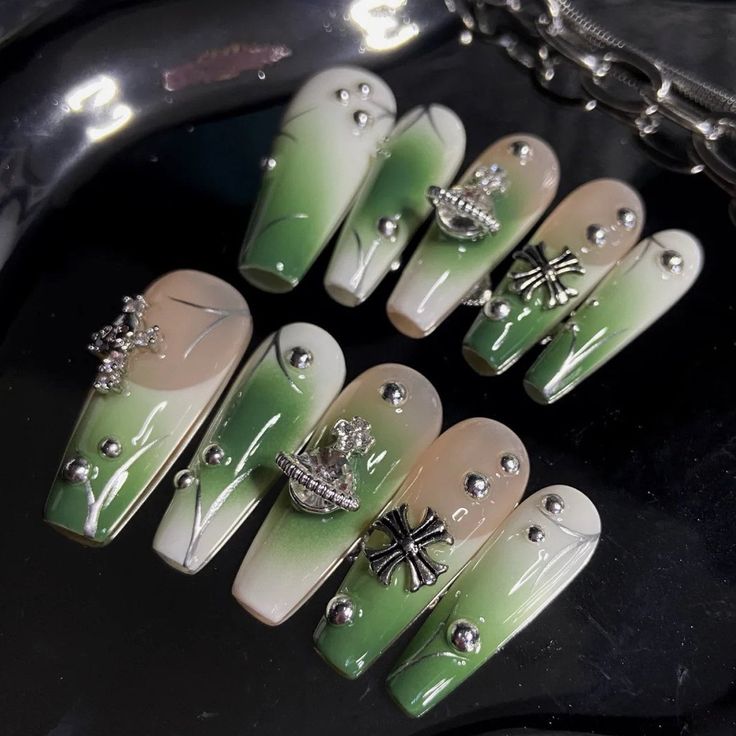 Elegant Trendy Green and Beige Gradient Nail Design with Intricate Embellishments.