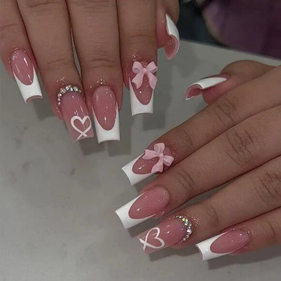 Romantic Pink and White Nail Design with French Tips, Bows, Hearts, and Rhinestones.