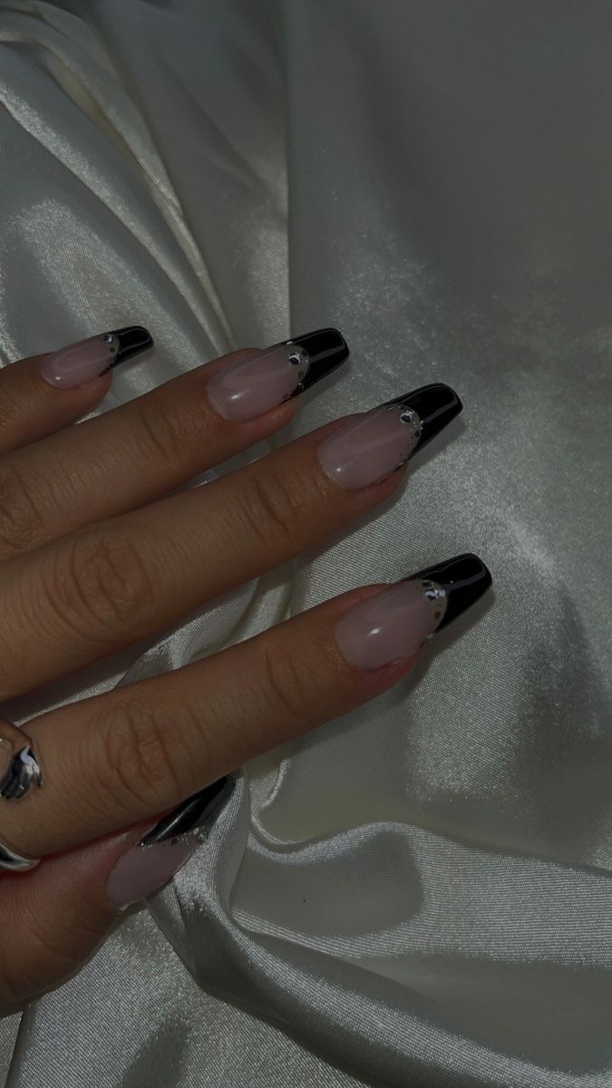 Chic Nude and Glossy Black Nail Design with Glamorous Embellishments.