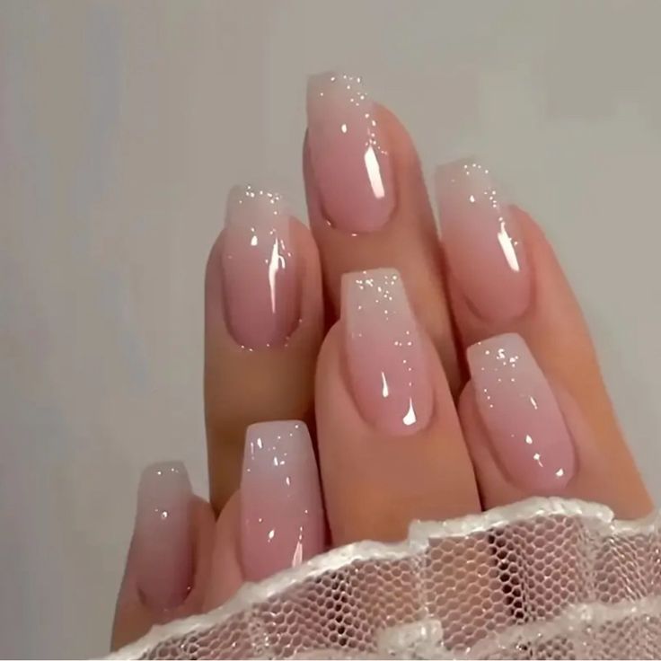 Elegant Ombre Nail Design with Soft Pink Gradient and Sparkling Accents.