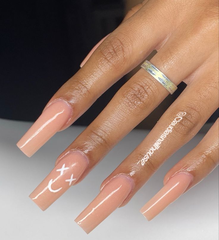 Chic Warm Nude Acrylic Nails with Playful Minimalist Designs for a Modern Elegant Look.