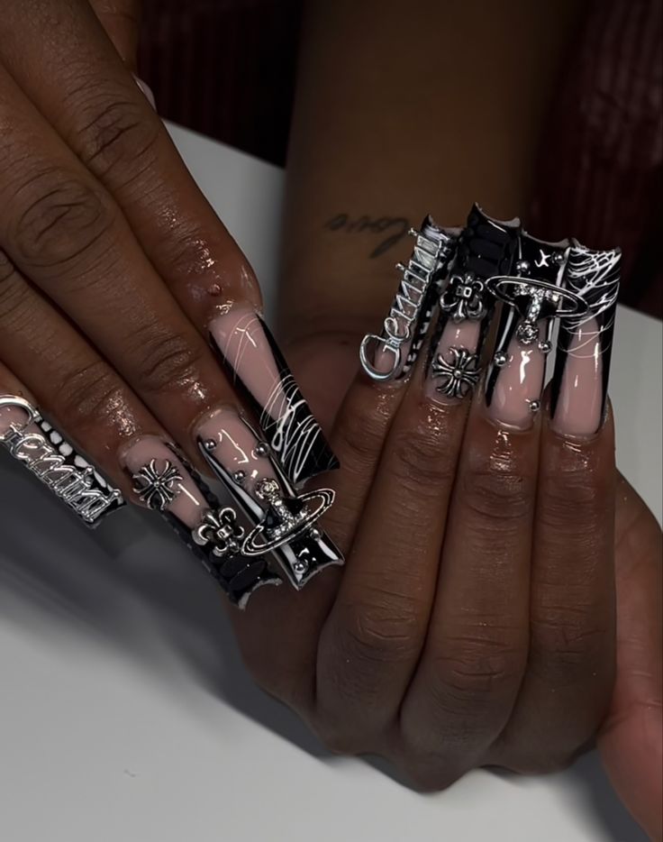 Bold and Edgy Nail Art: Glossy Nude with Intricate Black Designs and Metallic Embellishments