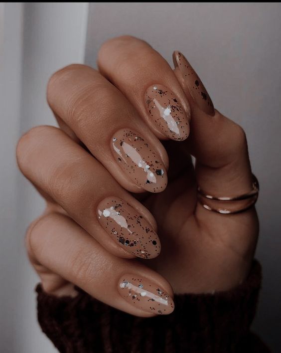 Sophisticated Elegant Nude Nails with Black and Silver Specks for Understated Glamour.