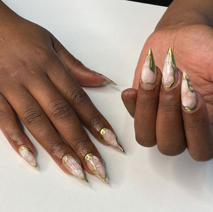 Luxurious Elongated Nail Design with Marble Effects and Gold Accents.