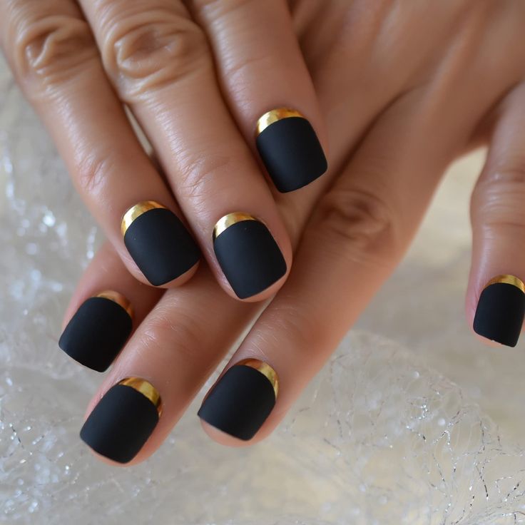 Chic Matte Black and Gold Half-Moon Nail Design.