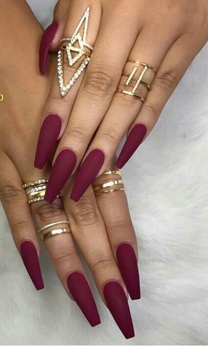 Sophisticated Burgundy Matte Nails Enhanced with Gold Rings for Versatile Glamour.