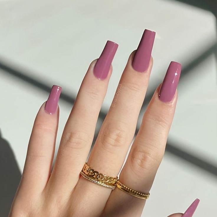 Chic Almond-Shaped Mauve Nails with Glossy Finish and Gold Ring Accents.