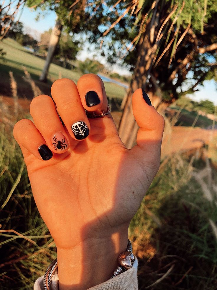 Spooky Seasonal Nail Design: Dark Polish with Intricate Spider Artwork