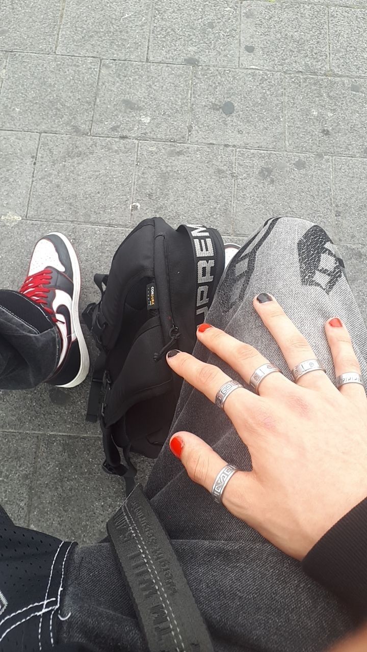 Bold Red and Black Nail Design Enhanced by Silver Rings for a Modern Streetwear Aesthetic.