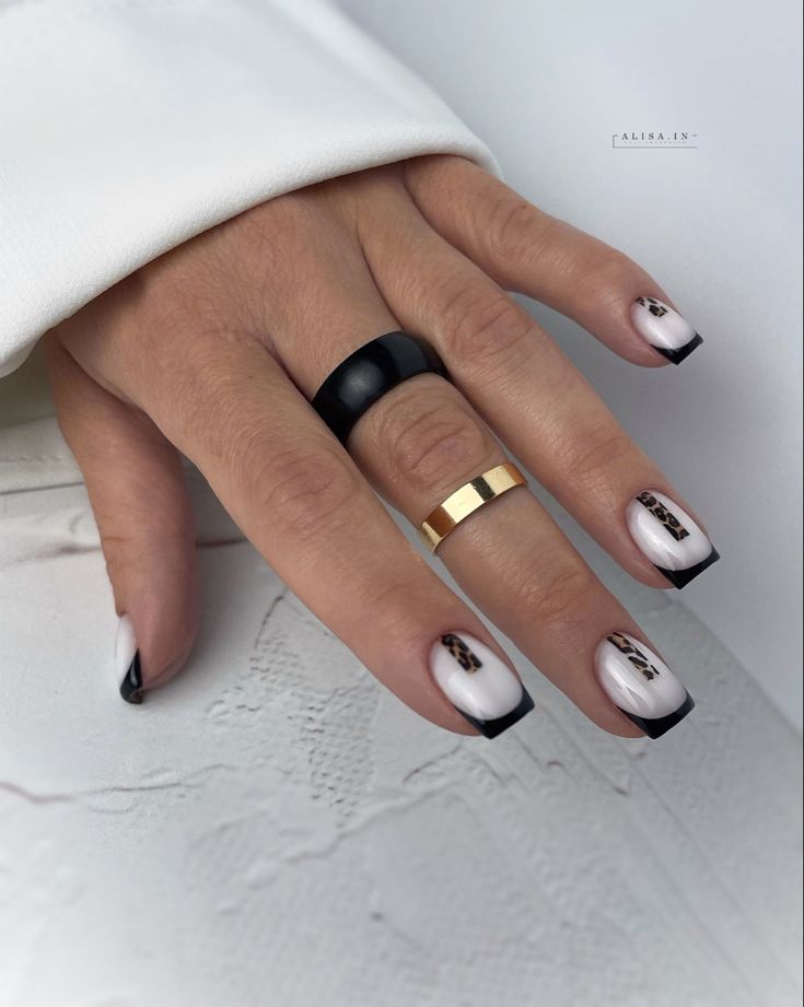 Chic French Manicure Redefined: Sleek Black Tips with Artistic Accents.