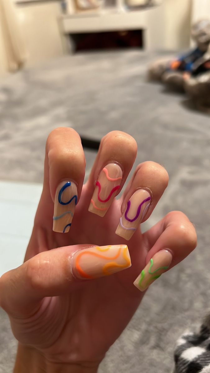 Playful Colorful Abstract Nail Design: Vibrant Swirls on Soft Nude Base.