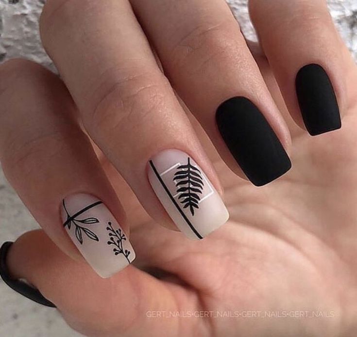 Sophisticated Matte Black and Pastel Nail Design with Artistic Leaf Artwork.