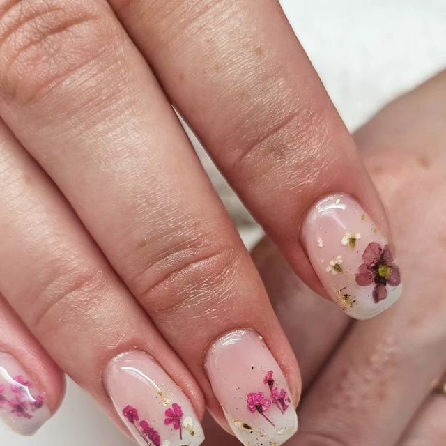 Elegant Floral Nail Design in Soft Pink with Metallic Accents and Gold Flecks