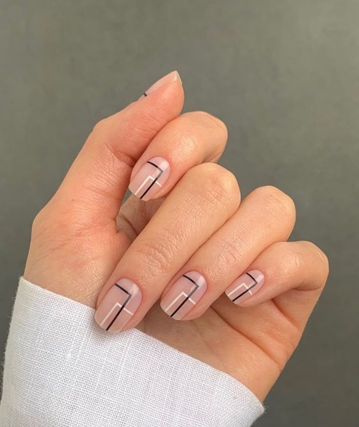 Elegant Geometric Nail Design with Soft Nude Base and Modern Black Lines.