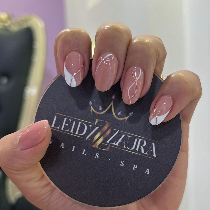 Chic Almond-Shaped Nails: Soft Nude Base with Classic White French Tips and Elegant Swirl Accents.